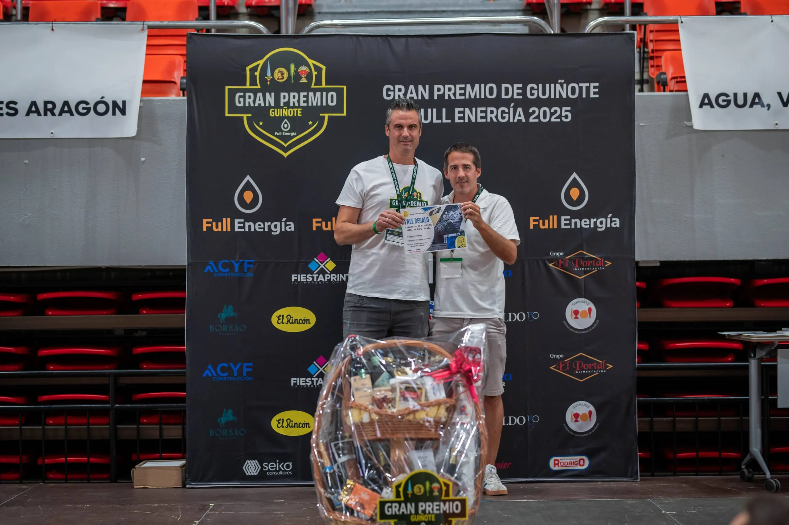 Un participante recoge su lote de obsequios en el photocall del torneo.