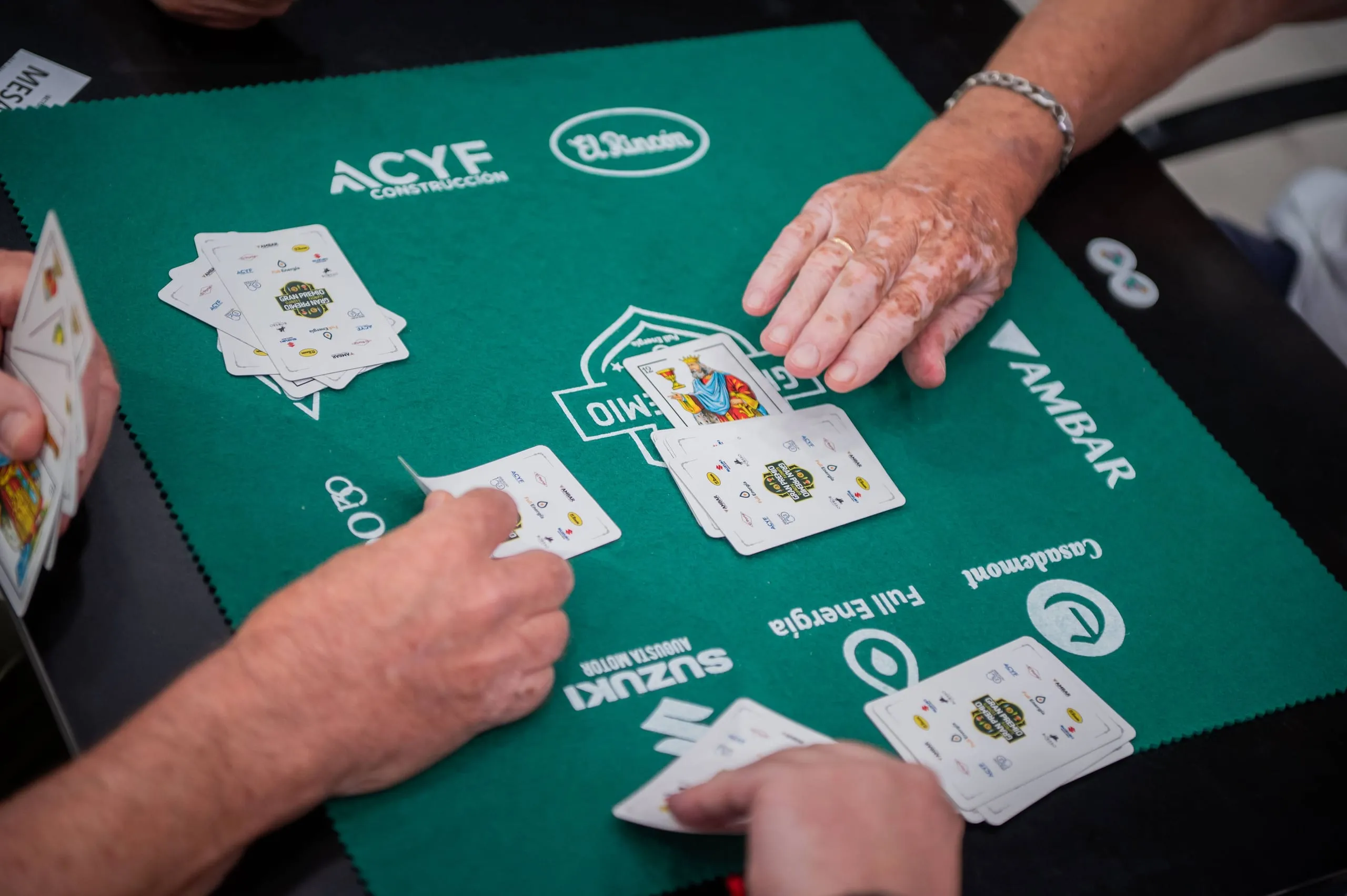 Dos jugadores enfrentados reparten las cartas sobre el tapete.